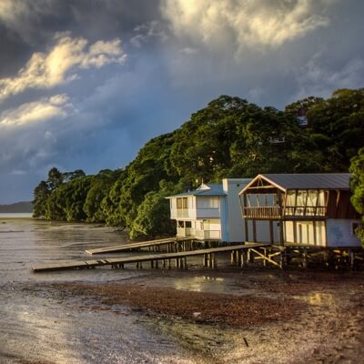 house with wooden boardwalk next to lake