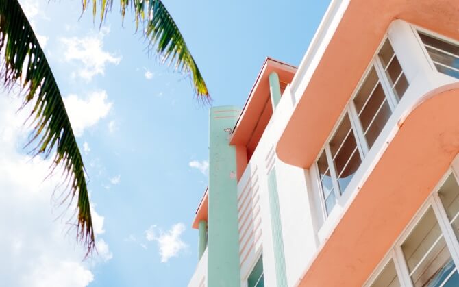 partial view of a small building next to palm tree
